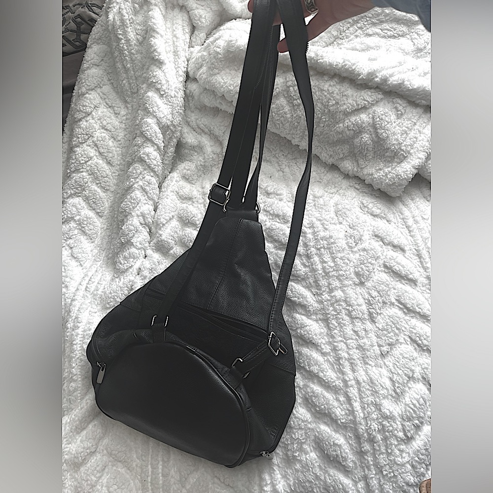 Black Leather material multiple pockets.can a be back pack or over the shoulder
